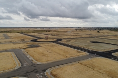 aerial view of land at beginning stages of development, with empty lots prepared for construction and paved streets