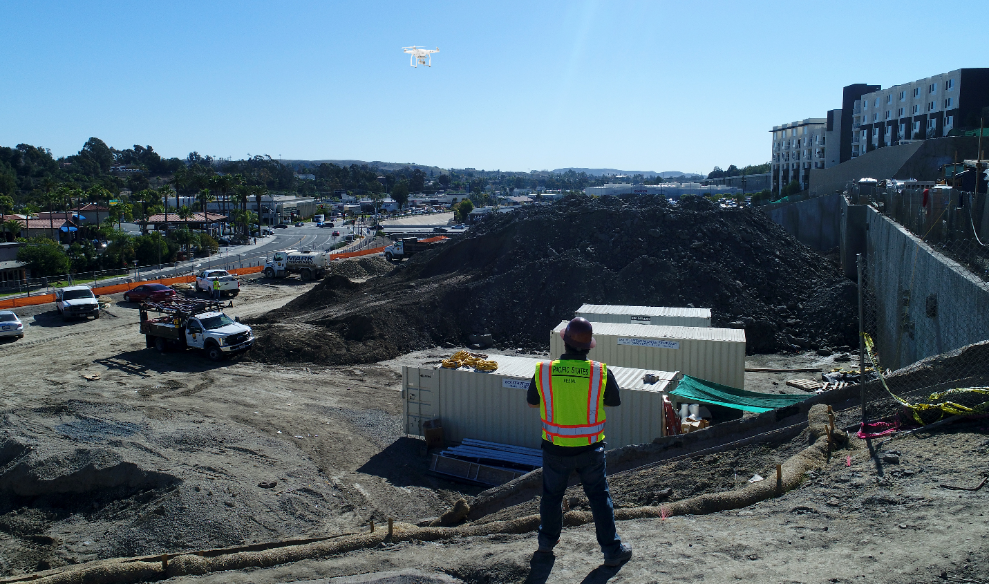 drone pilot flying drone over a stock pile at a construction site drone pilot flying drone over a stock pile at a construction site