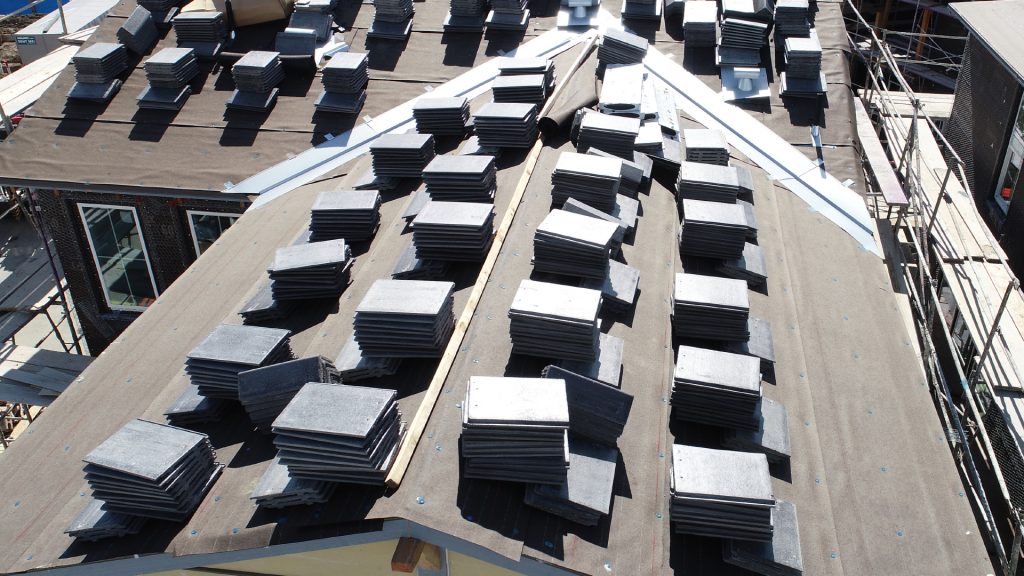 aerial closeup of unfinished roof with stacks of tile all over, used for safe and effective inspections of hard to access areas