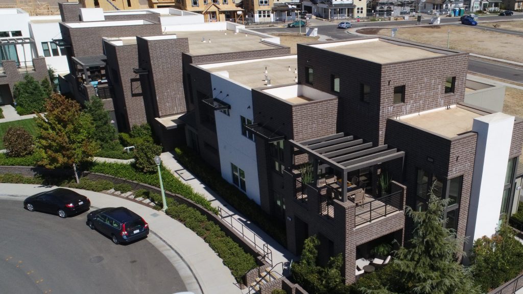 aerial view of a new development showing multiple buildings and lots at various stages of construction